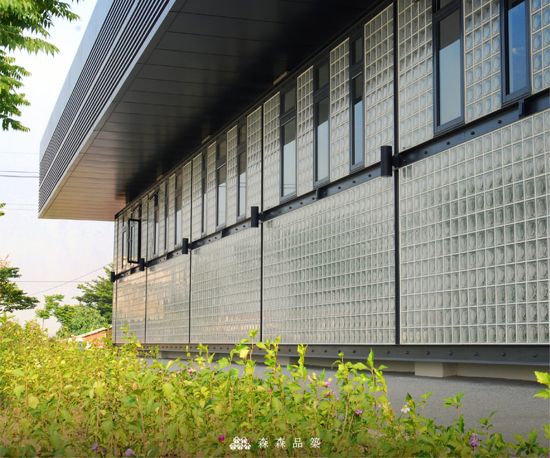 森森品築1908 Alpha全月紋玻璃空心磚建築外牆-新港藝術高中案例分享-與外觀一致的簡潔美，與一旁的植栽映照著，空心玻璃磚所帶出的多樣風格，讓您可細膩亦可率性。