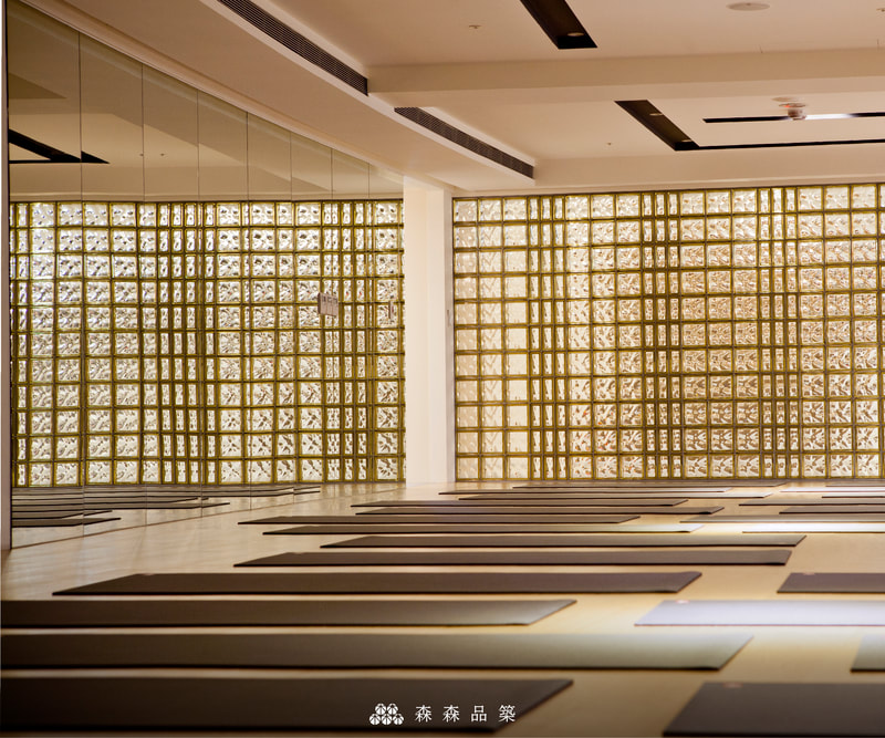 森森品築Q19 彩色玻璃空心磚商業空間隔間設計案例分享 - 玻璃磚牆選用經典棕黃彩色玻璃磚，搭配金屬塗層款，營造出豐富質感與光澤。巧妙地運用R09半磚與Q19全磚做搭配，創造出線條感。