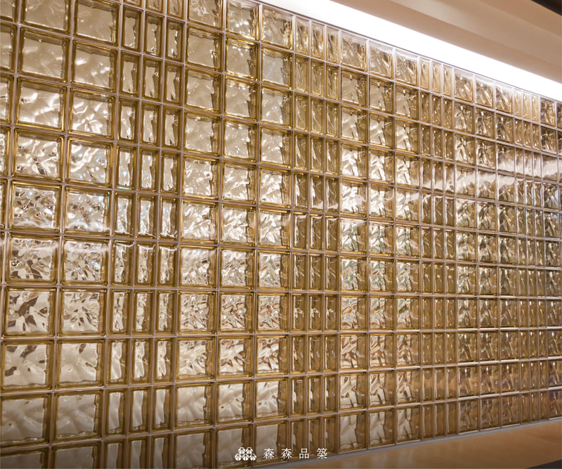 森森品築Q19 彩色玻璃空心磚商業空間隔間設計案例分享 - 棕黃色玻璃磚搭配棕黃色半磚，排列出更有設計感的格線，水波紋折射出不同光澤之下，營造出精品專櫃的高級質感。